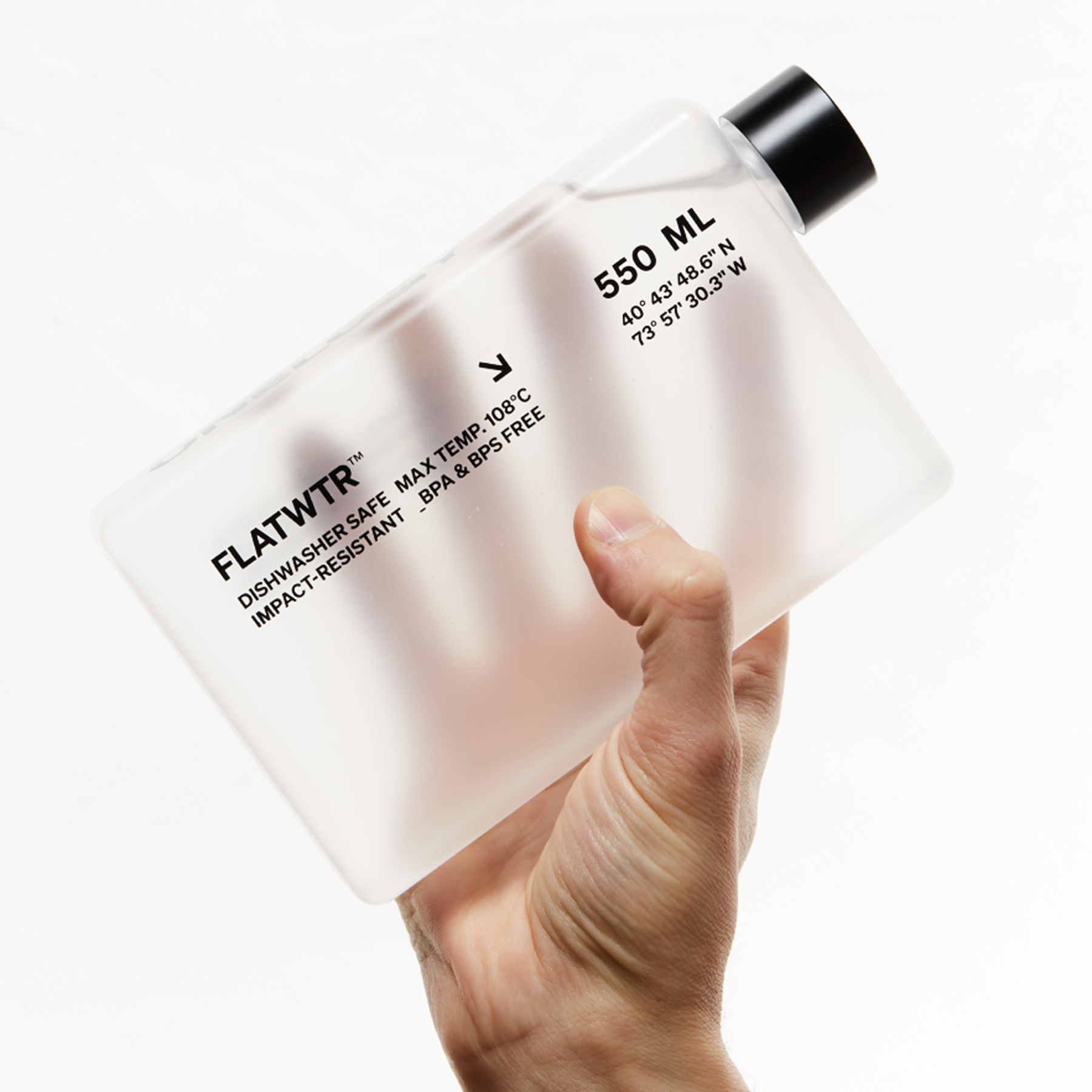 Hand holding a 550ml container labeled 'FLATWTR' against a white background