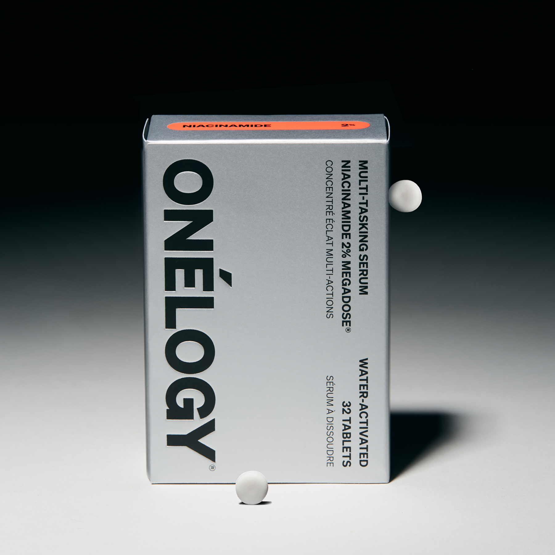 Onélogy multivitamin packaging with two tablets on a gradient background