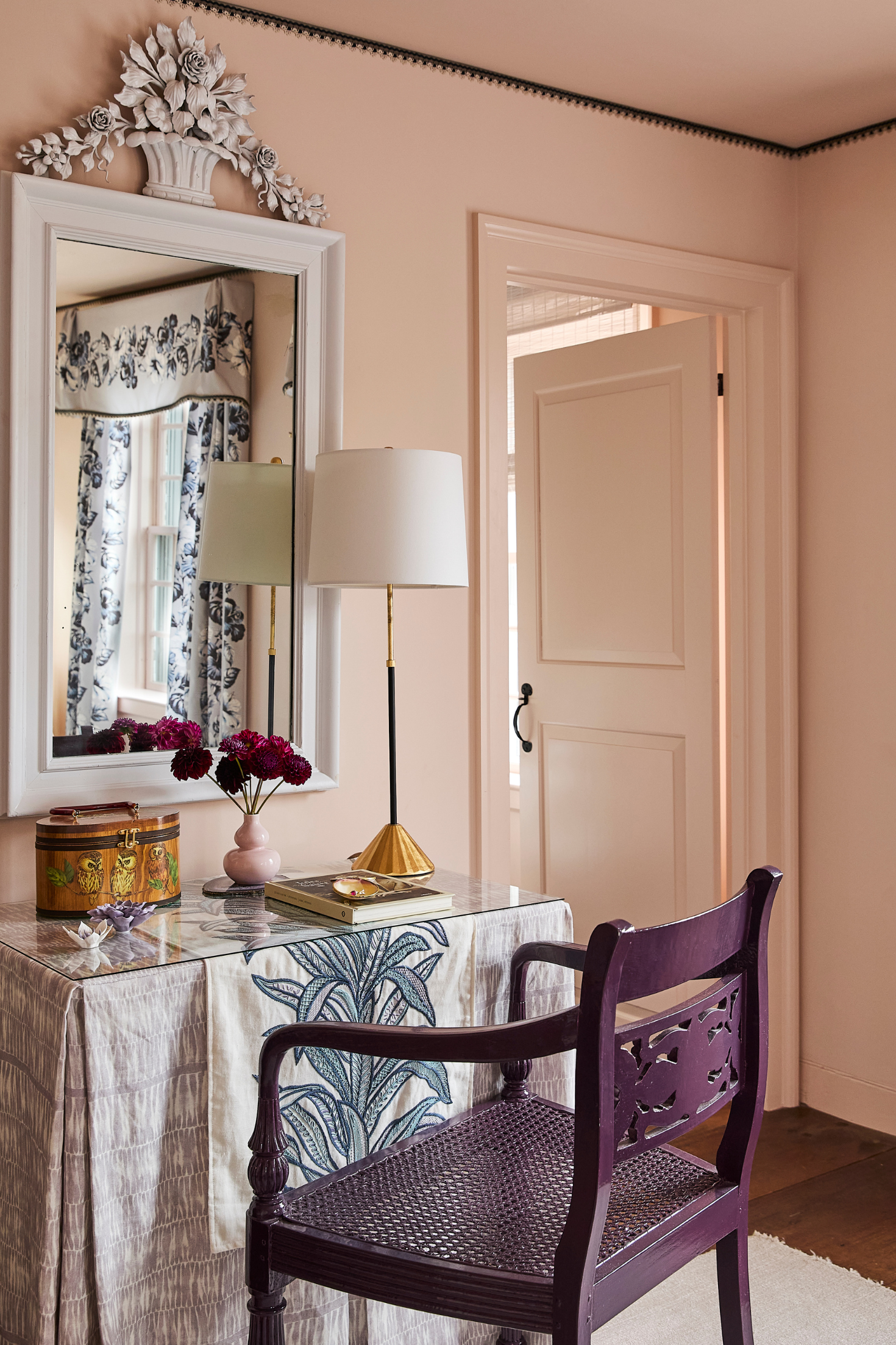 Decorative interior with a purple chair, table, and mirror.