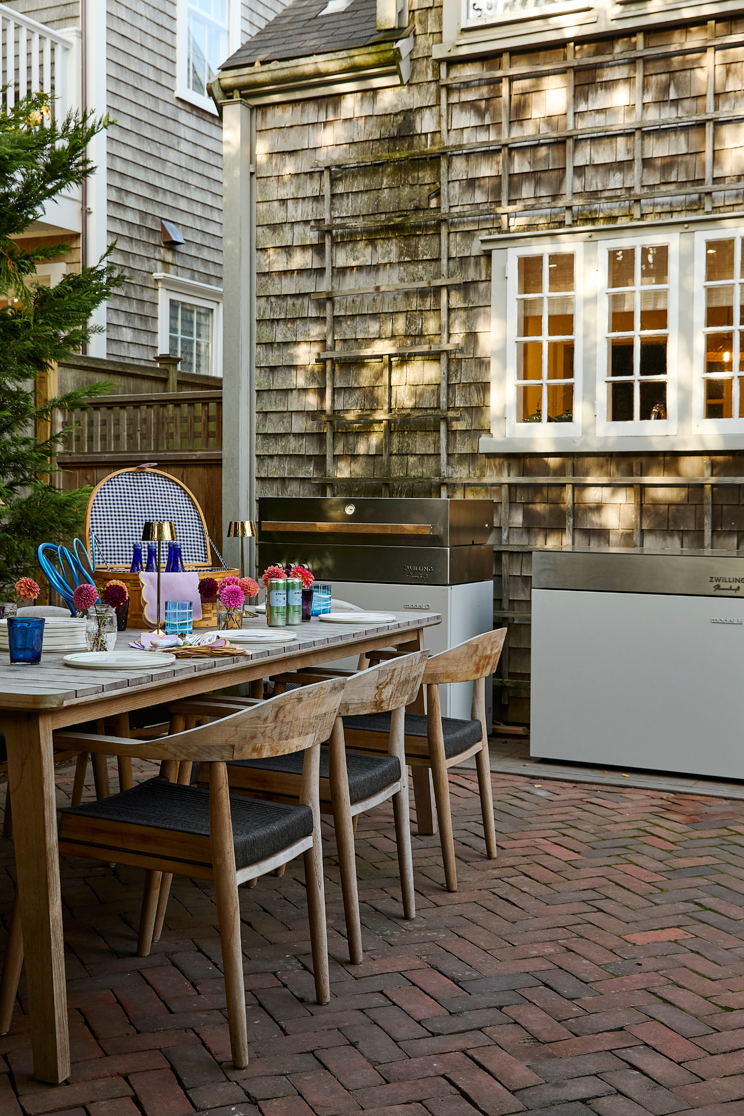 Outdoor dining area with wooden table and chairs in front of a wooden building.