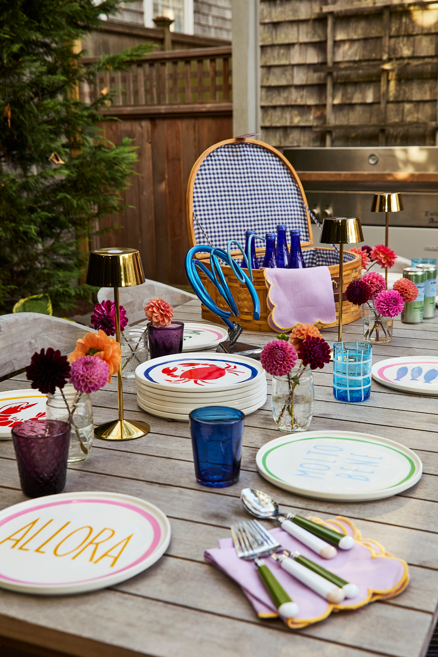 Outdoor dining setup with colorful tableware and decorations on a wooden table.