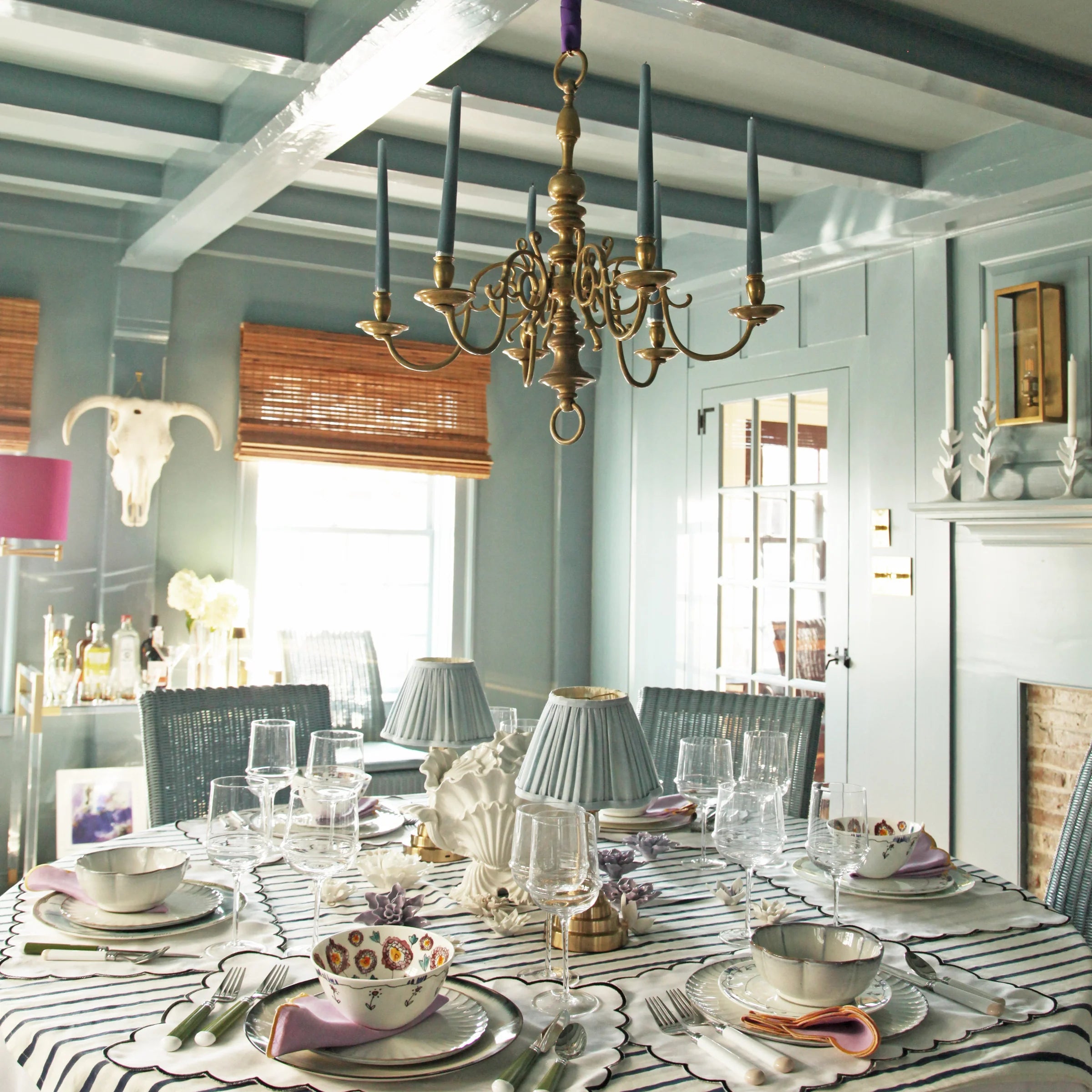 A dining table fully set underneath a golden chandelier