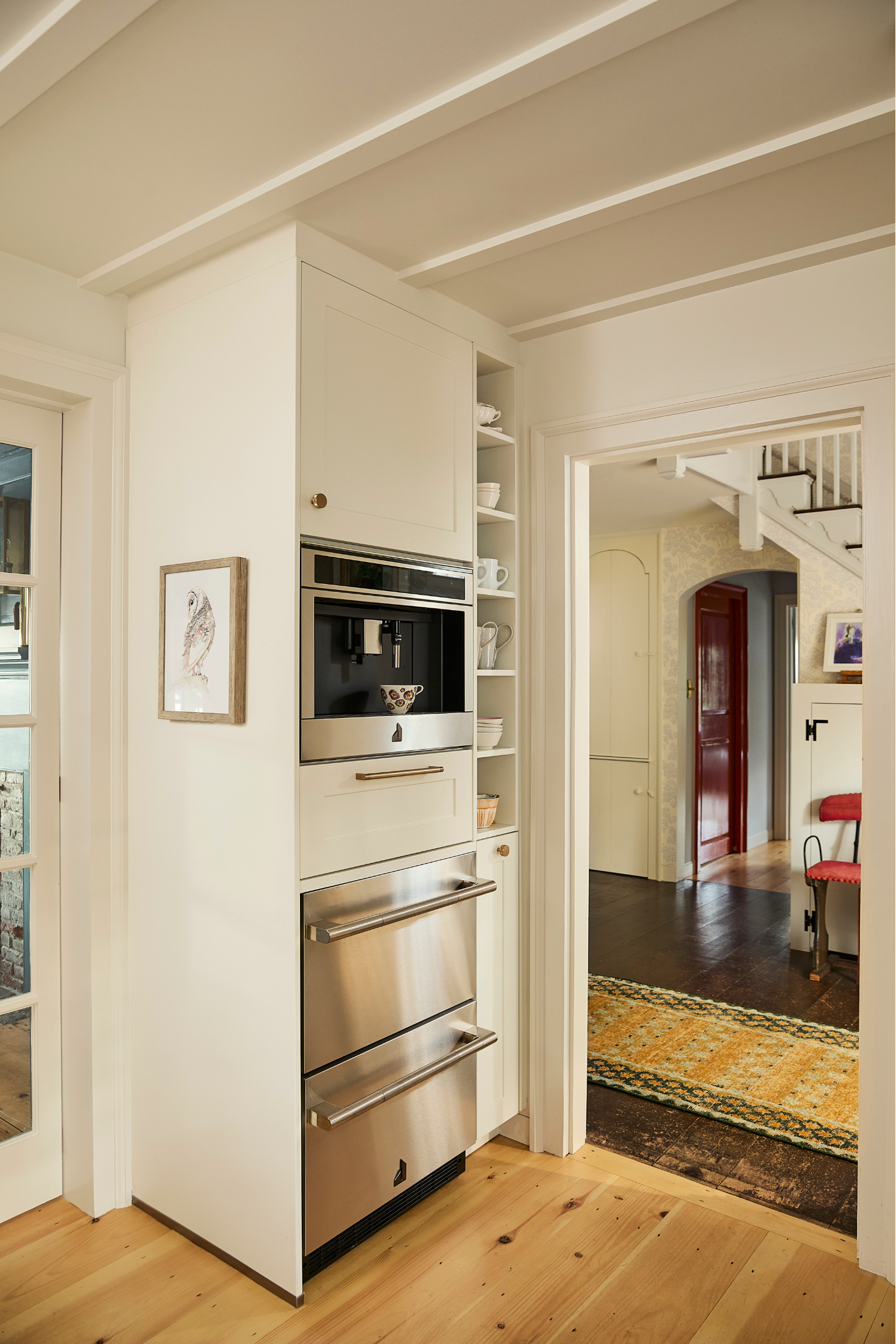Modern kitchen with stainless steel appliances and wooden flooring.
