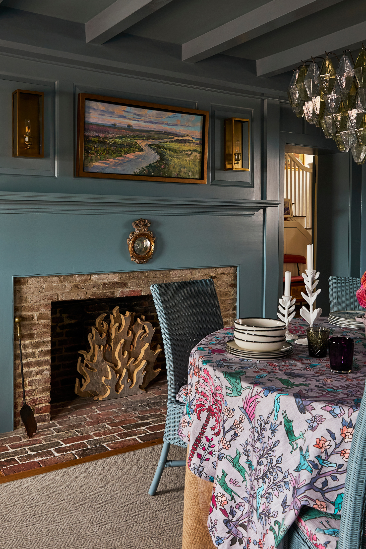 Cozy living room with a fireplace, floral tablecloth, and decorative items.