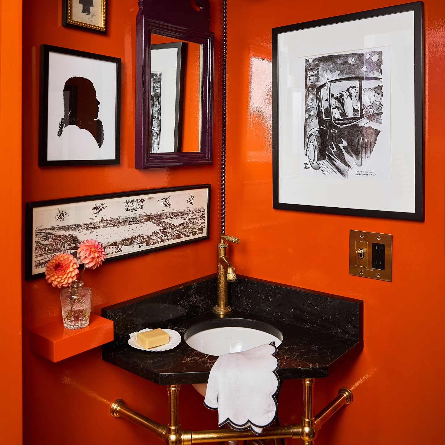 Small bathroom with orange walls, a sink, and framed pictures.