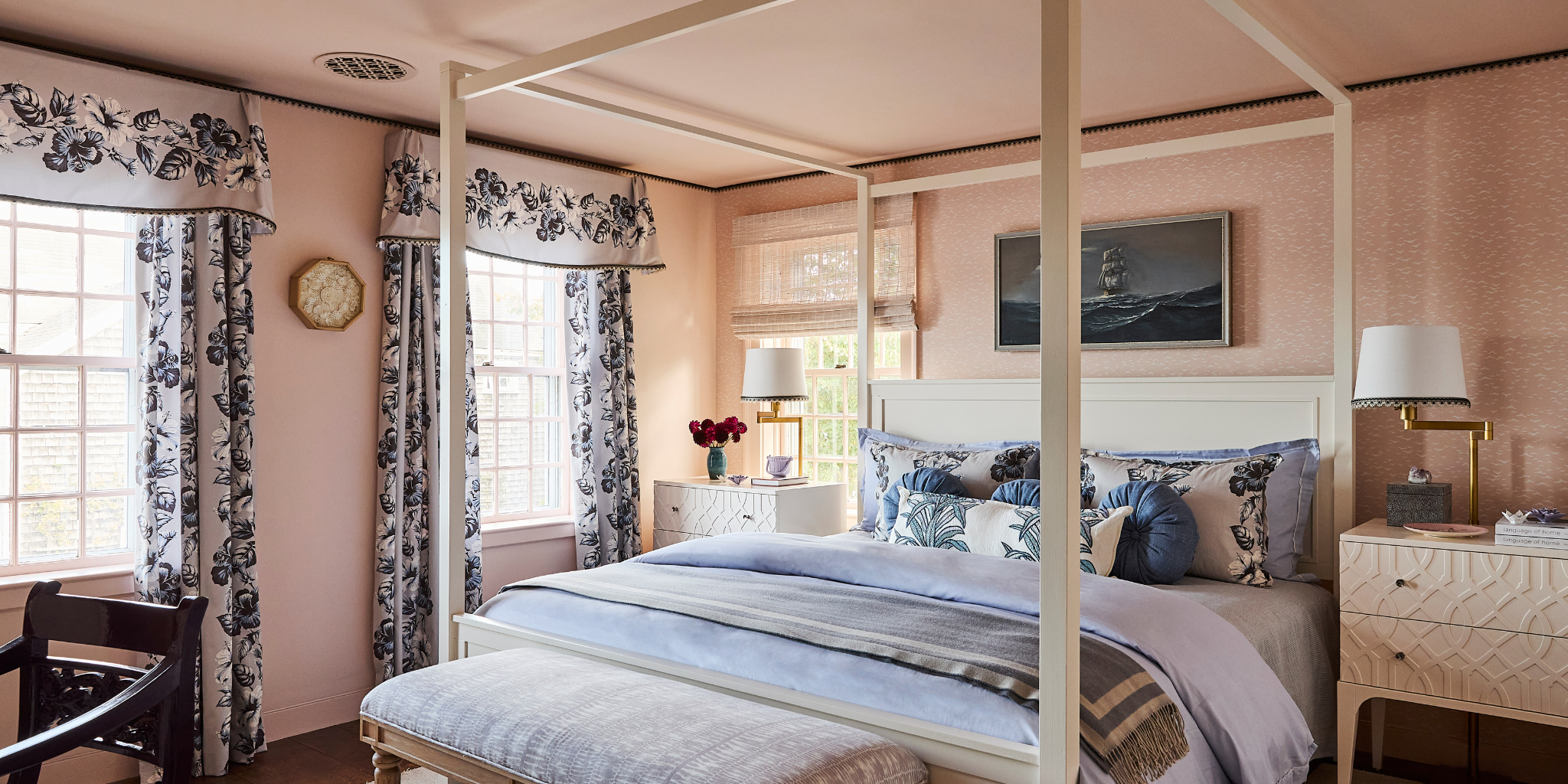A bed in a pink room with a beautiful bed frame and lovely bedding
